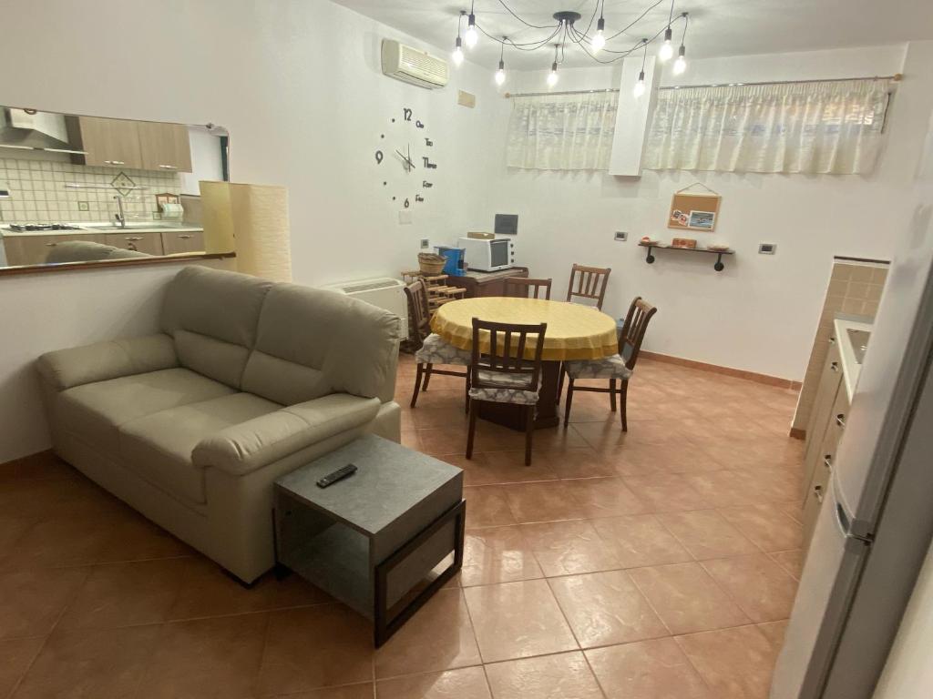 ein Wohnzimmer mit einem Sofa und einem Tisch in der Unterkunft Santa Marina Inn in Milazzo
