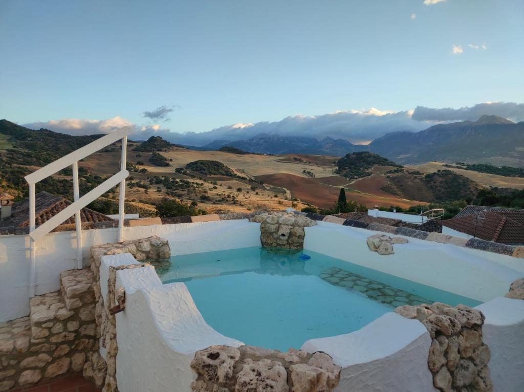 a large swimming pool with a view of the mountains at El molino del abuelo in Montecorto