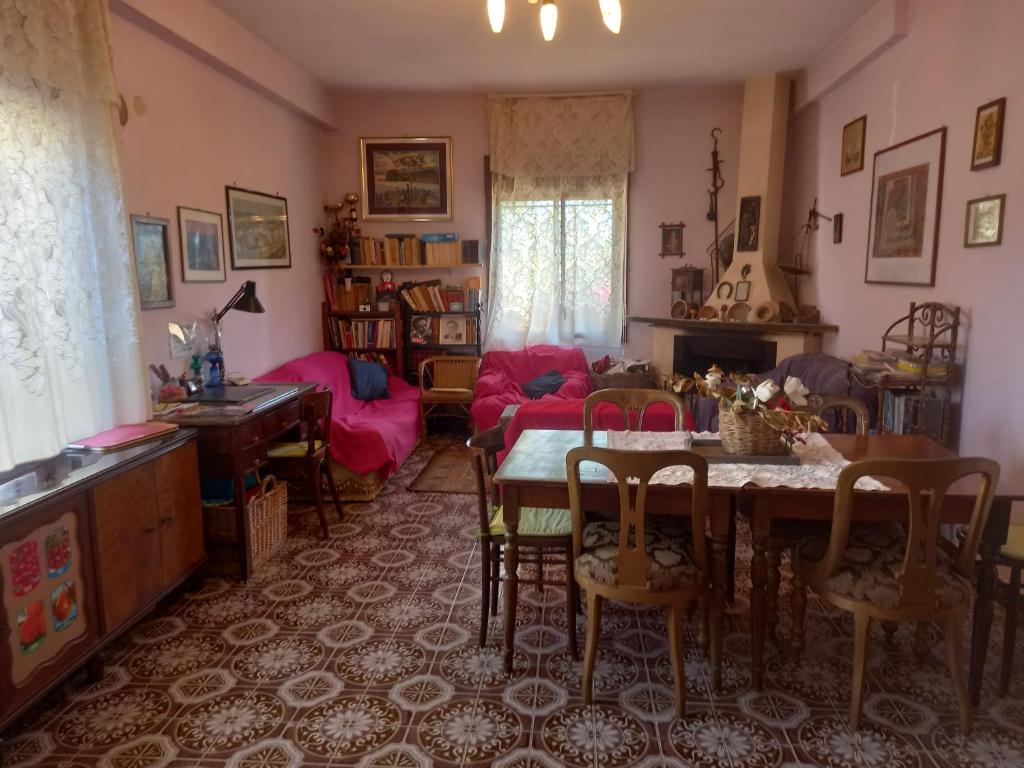 sala de estar con mesa y sofá en Calabria Melia di Scilla collina Antico Casale con giardino bio naturale, en Castagnarella