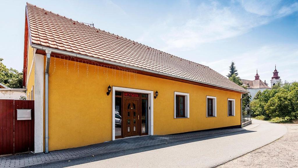 ein gelbes Gebäude mit einer Seitentür in der Unterkunft Pension U Zámku in Lechwitz