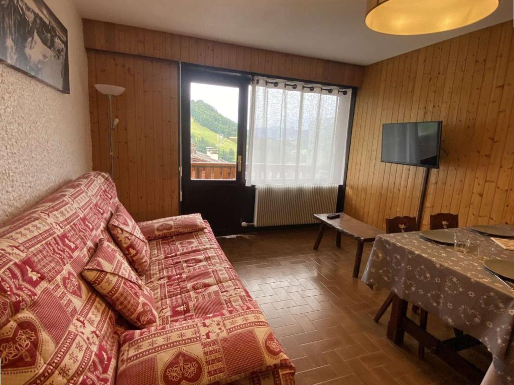 a living room with a couch and a table and a television at Appartement Le Grand-Bornand, 1 pièce, 4 personnes - FR-1-241-37 in Le Grand-Bornand