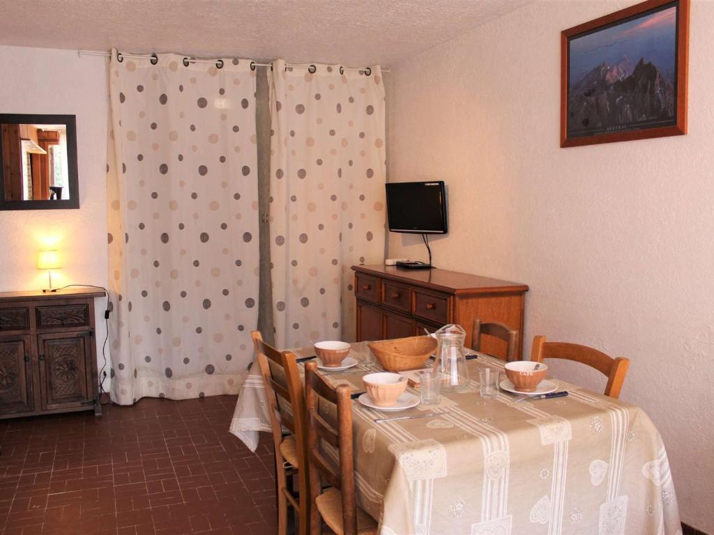 une salle à manger avec une table avec des chaises et une télévision dans l'établissement Studio Montagne 4 Pers, Balcon Sud, 100m des Pistes et 10m des Commerces à Vars Les Claux - FR-1-330B-150, à Vars