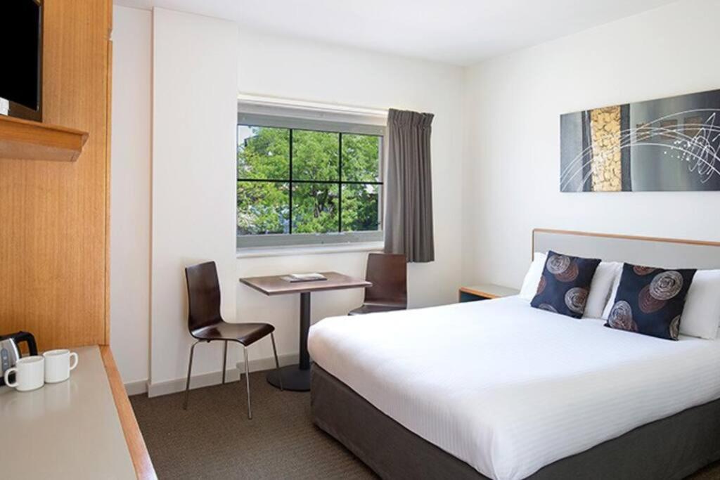 a hotel room with a large bed and a desk at 435/247 gouger st. ex hotel room in the city in Adelaide