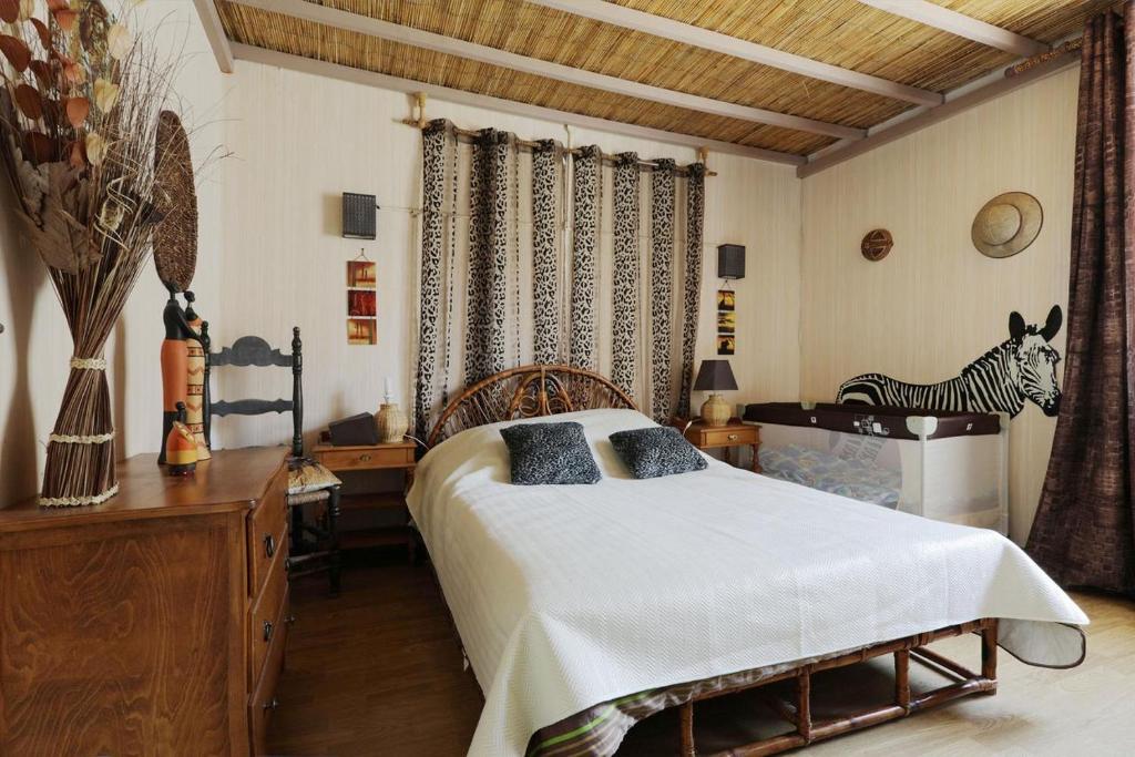 1 dormitorio con 1 cama y 1 cebra en la pared en Gîte les Hirondelles, en Caudiès-de-Fenouillèdes