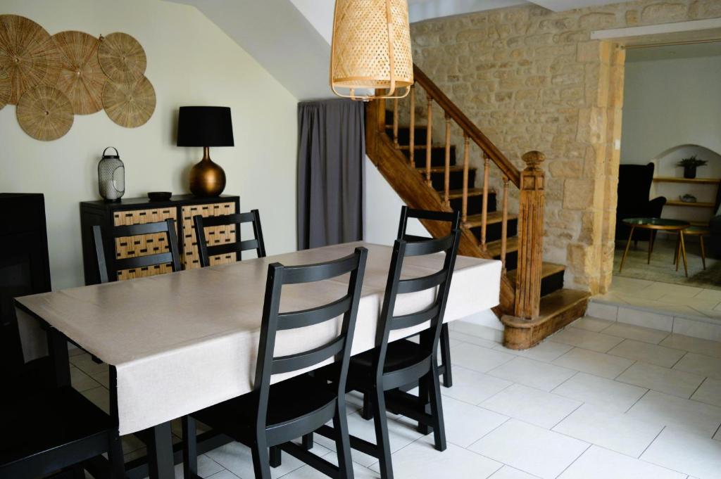 Un comedor con mesa y sillas en Halte Lutine - Maison chaleureuse en pierres, en Luc-sur-Mer