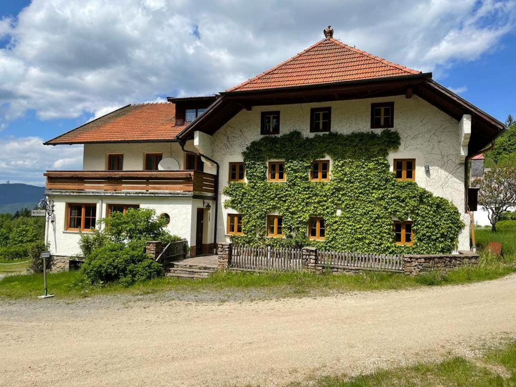 a house with ivy growing on the side of it at Ferienwohnung Gut Eschlsaign in Arrach