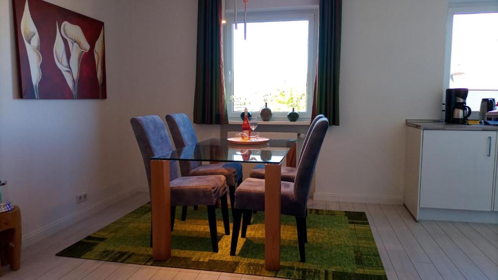d'une salle à manger avec une table, des chaises et une fenêtre. dans l'établissement Südblick Sylt, à Westerland