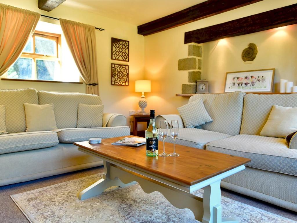 a living room with couches and a table with wine glasses at Pass the Keys Cosy Rural 2 Bed Barn conversion close to Beach 