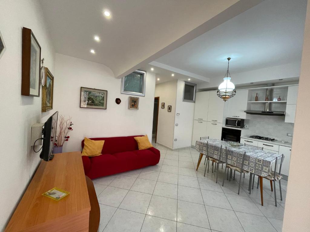 sala de estar con sofá rojo y mesa en Casa Milano - Sottomarina en Sottomarina