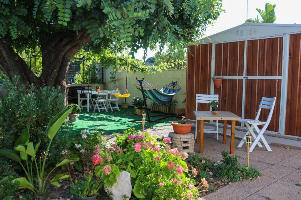 La Casa del Carrubo في كالياري: حديقة فيها أرجوحة وطاولة وكراسي
