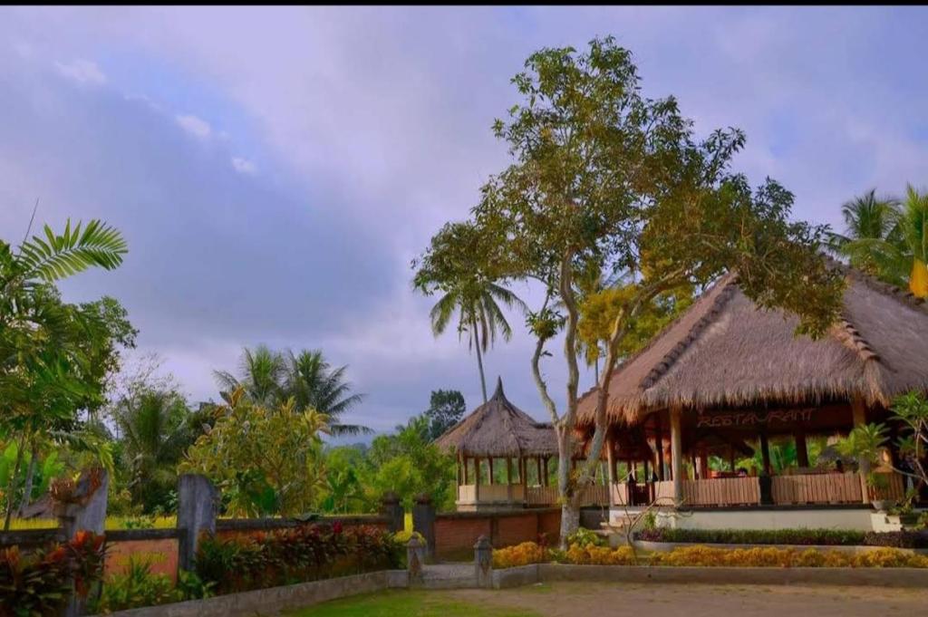 ein Gebäude mit einem Pavillon im Garten in der Unterkunft Hakiki Inn Bungalows in Tetebatu