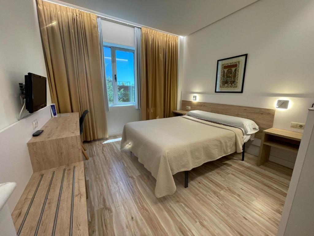 Una habitación de hotel con una cama y una ventana. en Hotel Concordy, en Madrid