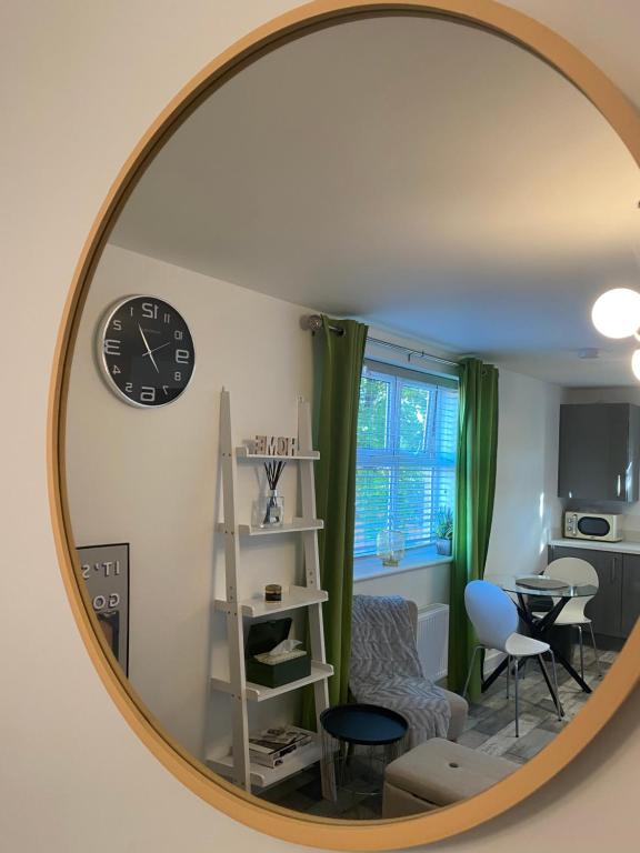 a mirror reflecting a living room with a clock on the wall at Peterborough Brand New City Center Apartment 2 Bedroom 2 bath apartment free parking contractors welcome in Peterborough