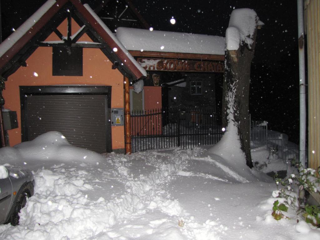 una pila de nieve frente a un garaje en "Jackowa Chata", en Szklarska Poręba