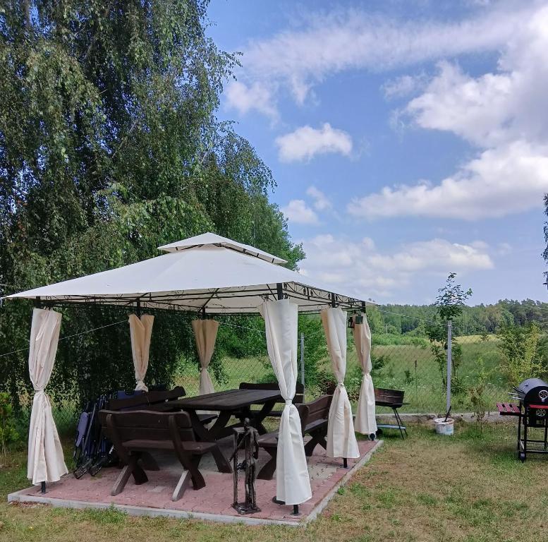 altana ze stołem piknikowym na polu w obiekcie Wynajem pokoi WIKI w mieście Mikołajki