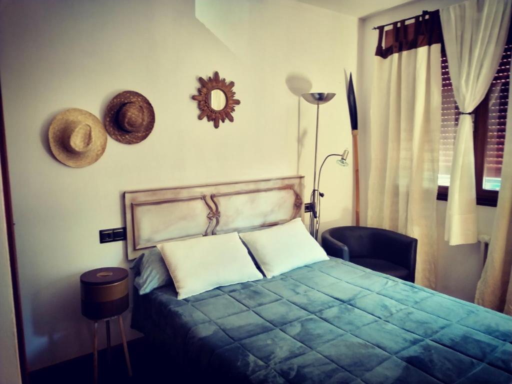 Un dormitorio con una cama y un sombrero en la pared en Virxen do Carmen 7 alojamiento, en Puentecesures