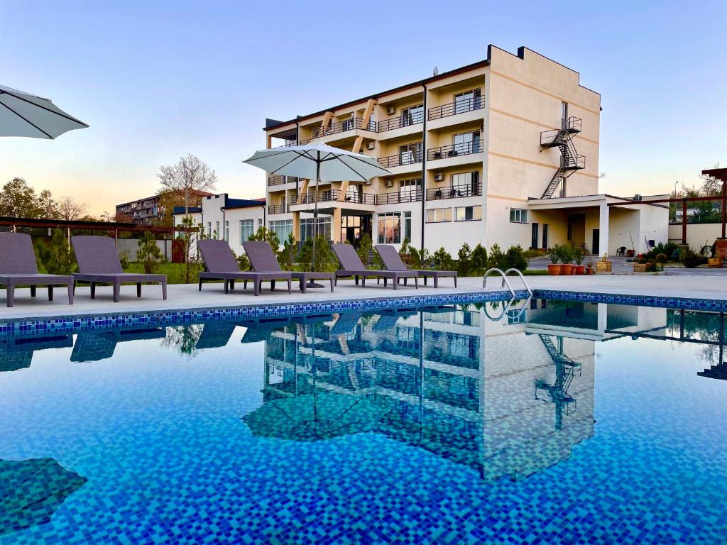 un hôtel avec une piscine en face d'un bâtiment dans l'établissement The Wine Hotel Telavi, à Telavi
