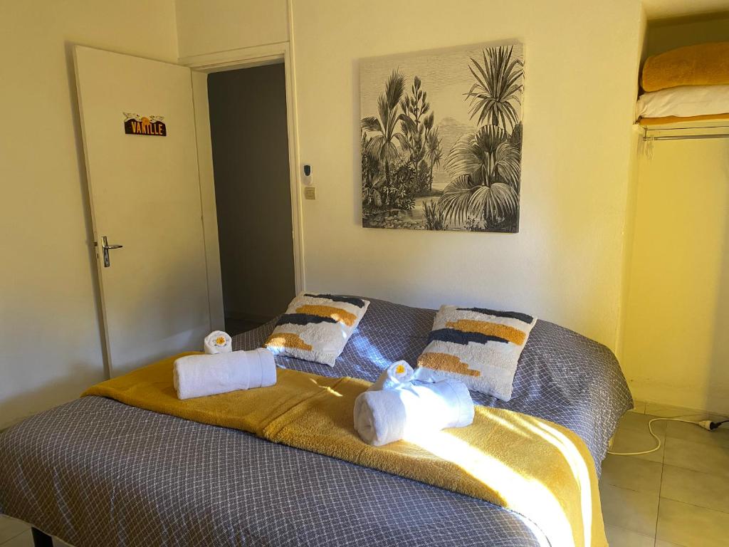 1 dormitorio con 1 cama con toallas en Ti kaz bo - Chambre vanille chez l'habitant en Bras-Panon