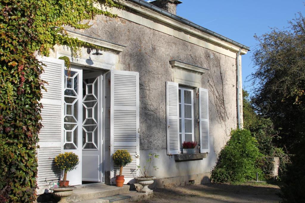 Cette maison ancienne dispose d'une porte et de fenêtres blanches. dans l'établissement Le Domaine Du Cormier, à Orvault