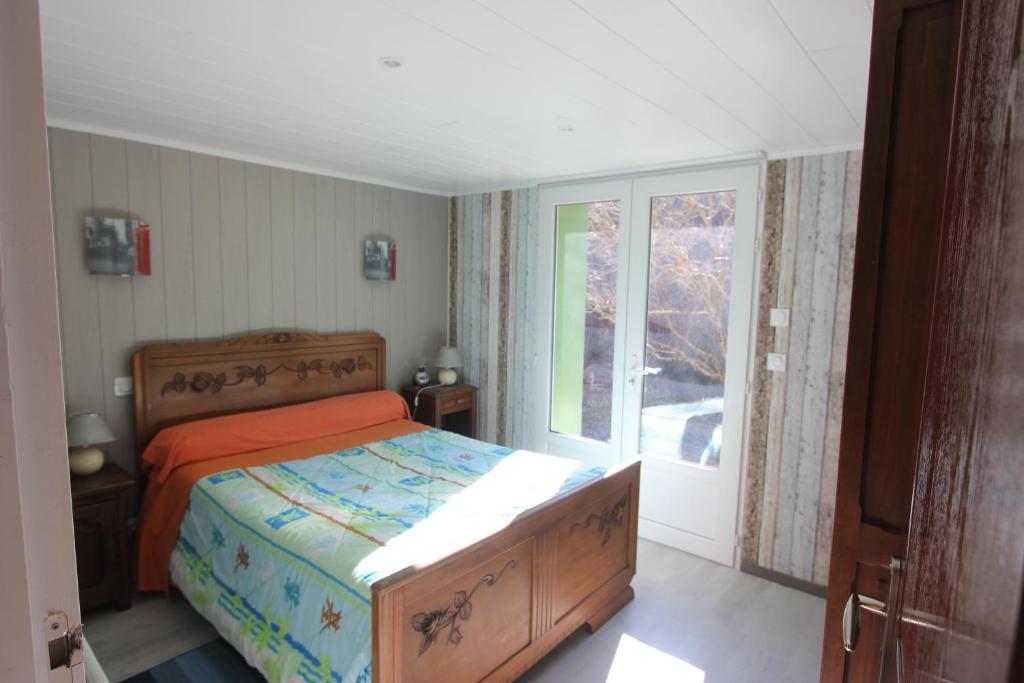 sypialnia z łóżkiem i dużym oknem w obiekcie Maison au bord de l'eau avec Jacuzzi w mieście Millau