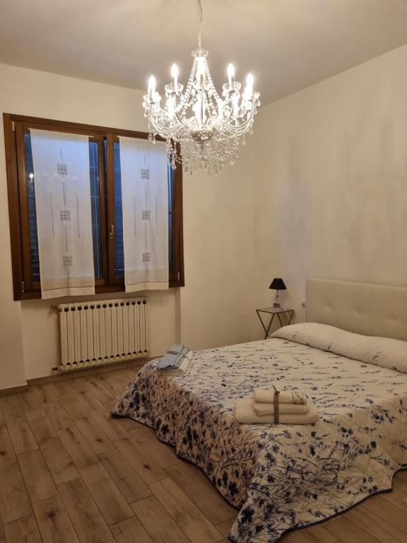 um quarto com uma cama grande e um lustre em Appartamento Via Loreto em Pistoia