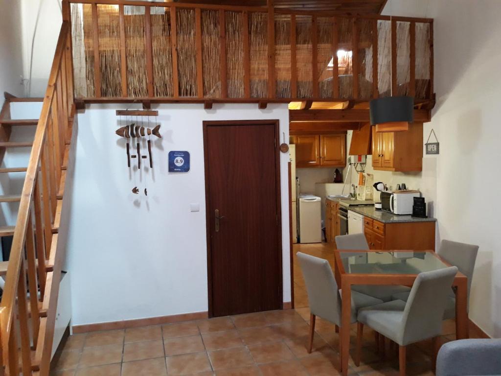 a small kitchen with a staircase leading up to a loft at CASA SÃO SEBASTIÃO Casas Bem Haja in São Miguel de Acha