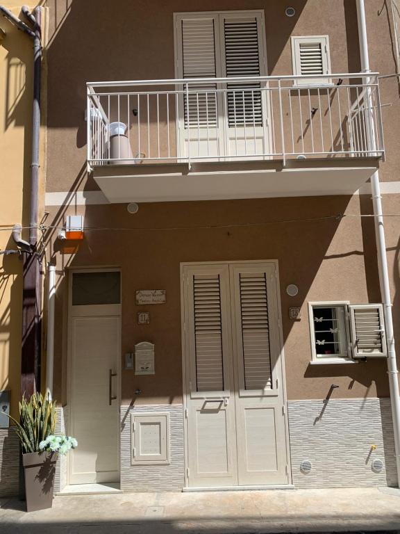 apartamentowiec z balkonem i drzwiami w obiekcie Denise Vacanze - Monolocali arredati w mieście Bagheria