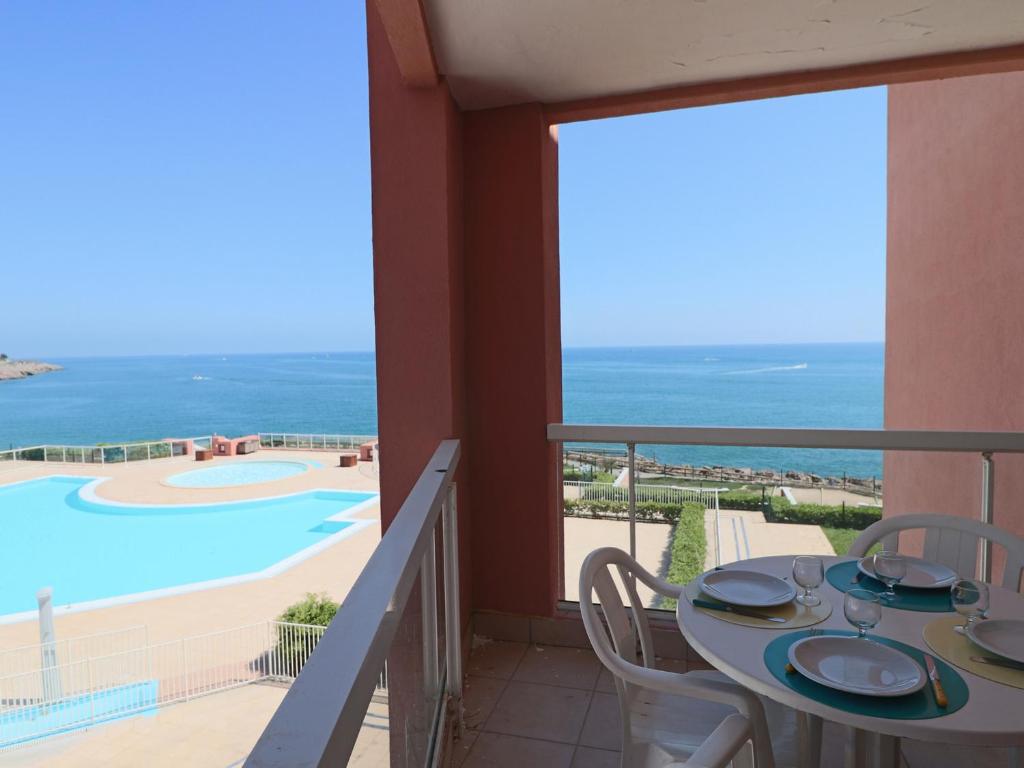 un balcon avec une table et une vue sur l'océan dans l'établissement Appartement 2 pièces avec piscine et parking à Sète - FR-1-472A-147, à Sète