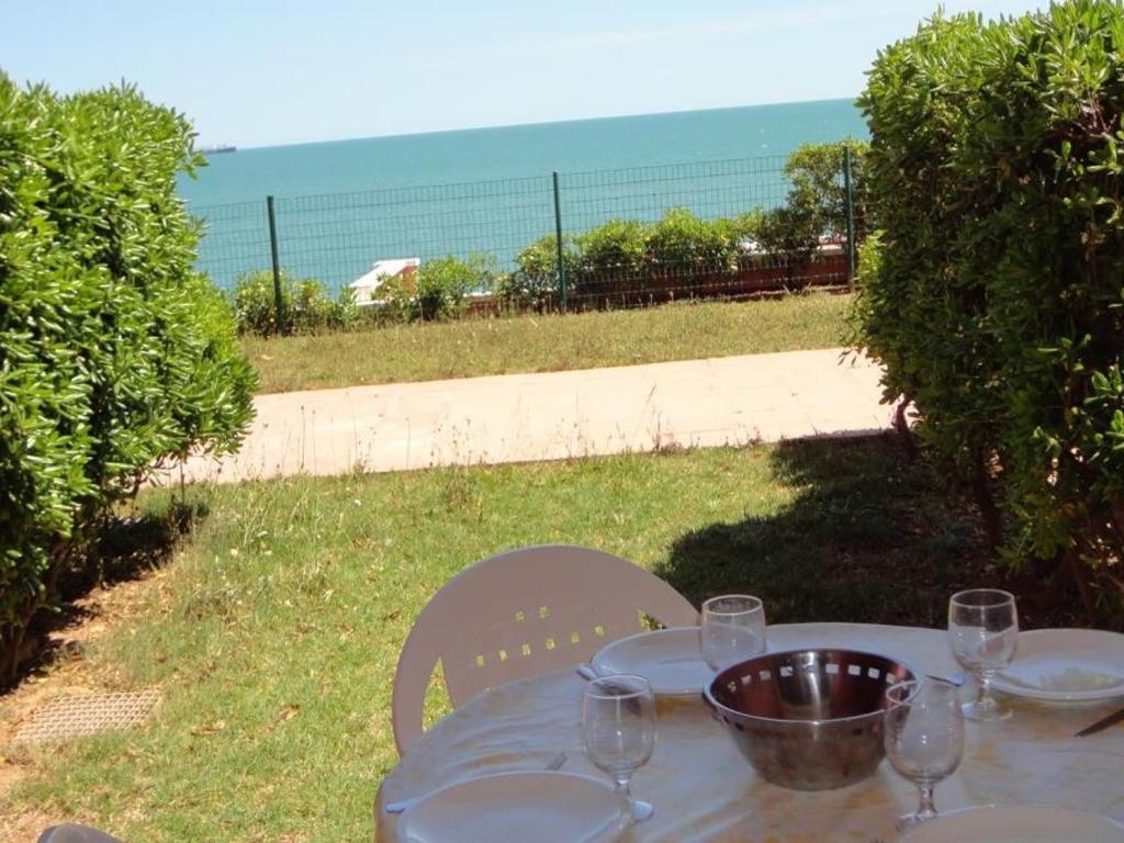 - une table avec des verres à vin et un bol dans l'établissement Rez-de-jardin à Sète: 2 pièces, piscine, parking, terrasse - FR-1-472A-129, à Sète