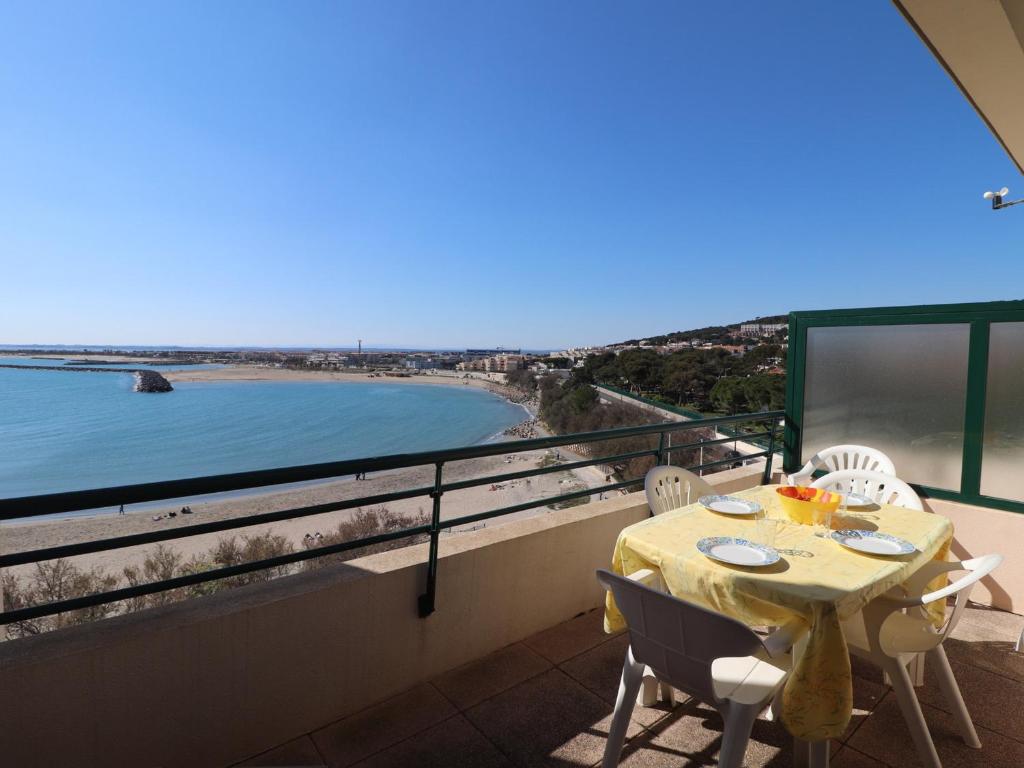 une table et des chaises sur un balcon avec vue sur l'océan dans l'établissement Appartement 40m² avec terrasse et 2 chambres à 4, face à la plage du Lazaret - FR-1-472A-157, à Sète