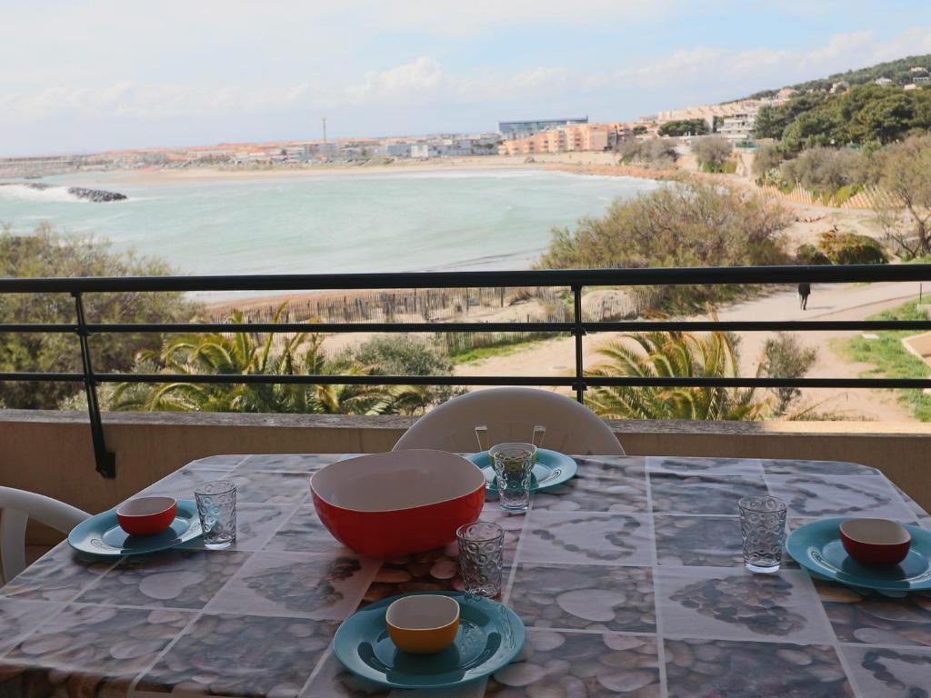 - une table sur un balcon avec vue sur la plage dans l'établissement Appartement 2 pièces, terrasse 14m², face plage, pour 6 personnes, classé 2* - FR-1-472A-173, à Sète