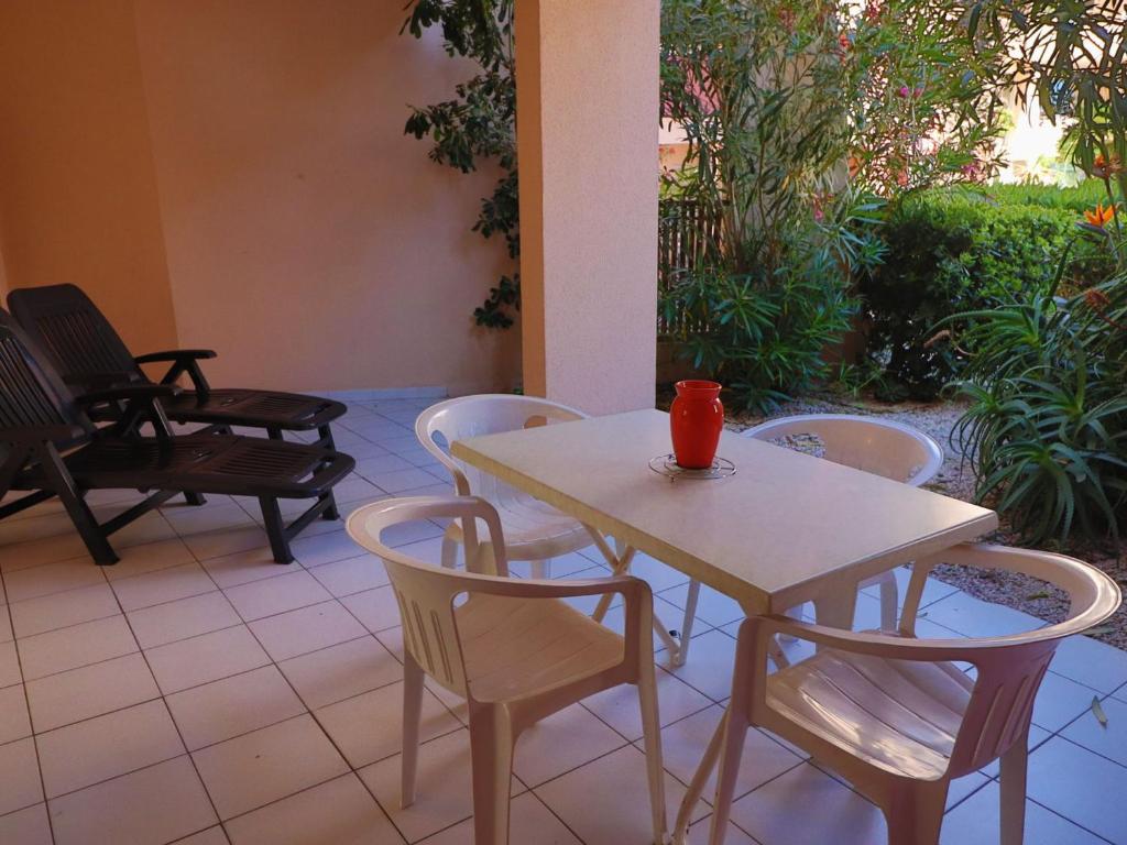 - une table et des chaises sur une terrasse avec une tasse dans l'établissement Spacieux rez-de-jardin avec terrasse et accès direct à la piscine à Sète - FR-1-472A-171, à Sète