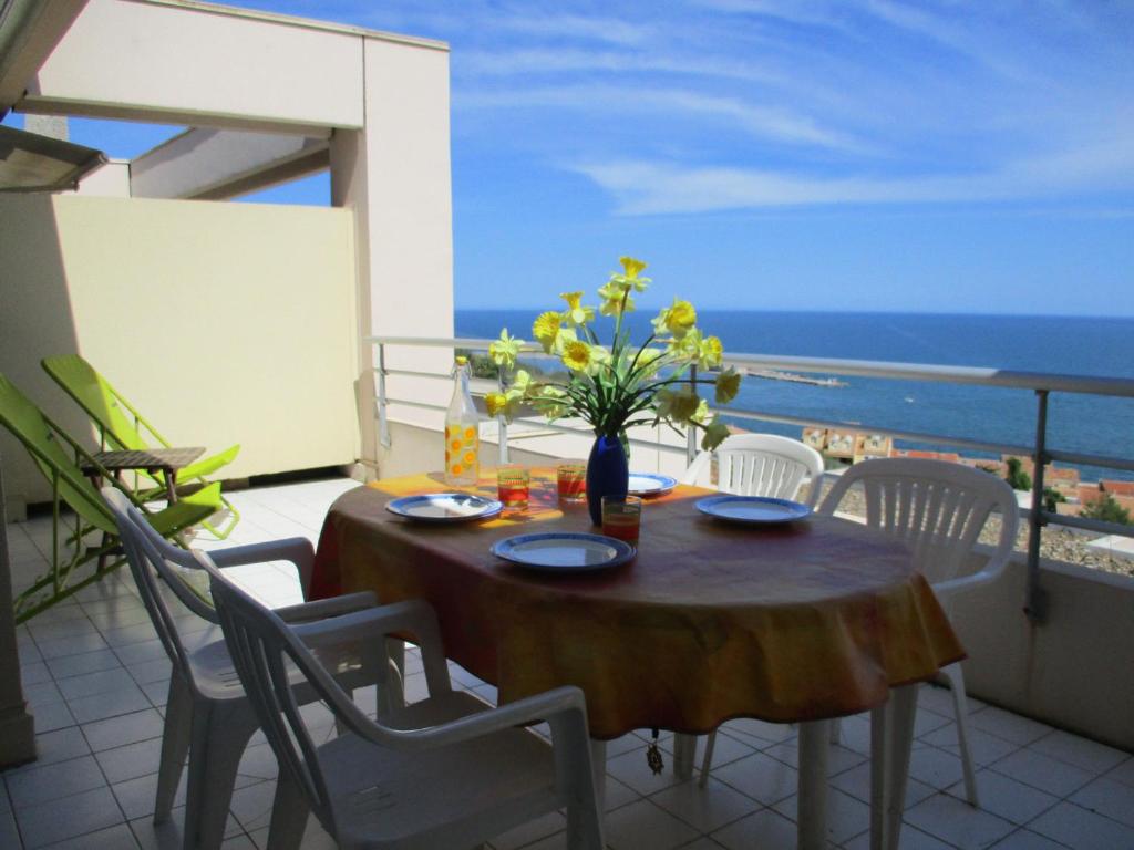une table avec un vase de fleurs sur un balcon dans l'établissement Appartement 2 Pièces Cabine, Terrasse Vue Mer & Parking Privé - FR-1-472A-214, à Sète