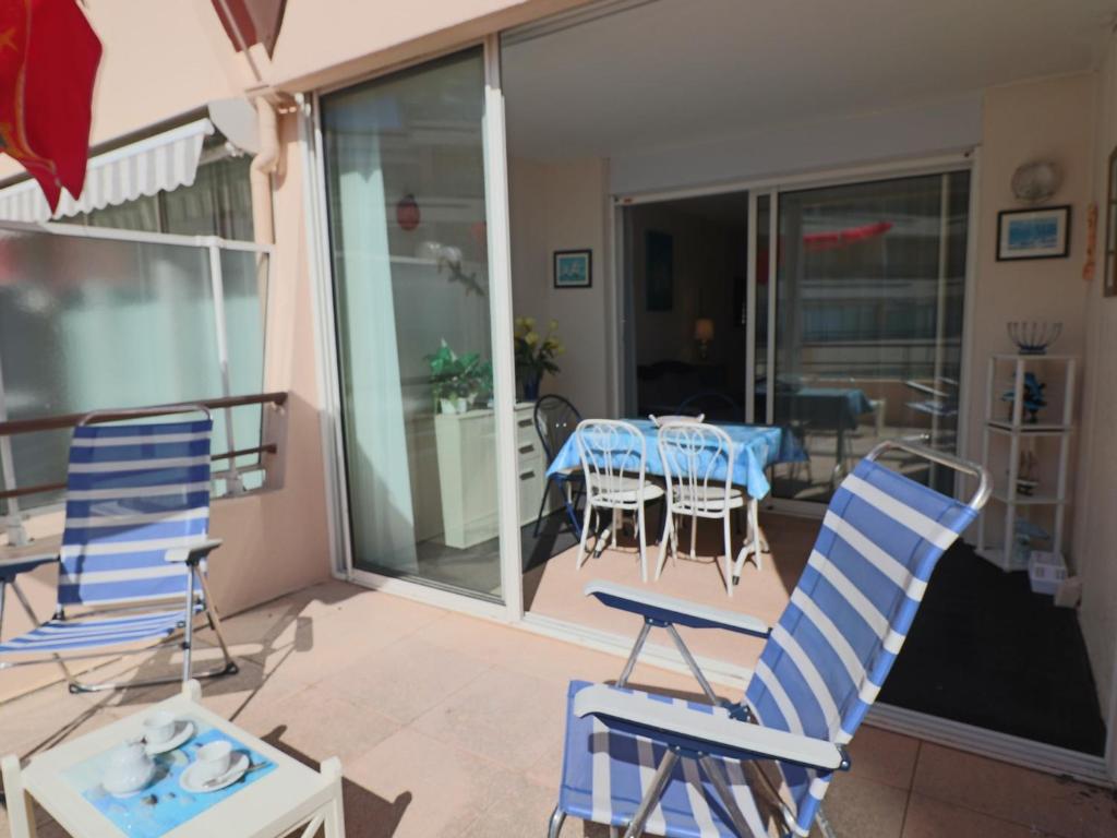 d'une terrasse avec des chaises bleues et une table sur un balcon. dans l'établissement Appartement climatisé avec terrasse et vue mer, parking - FR-1-472A-194, à Sète