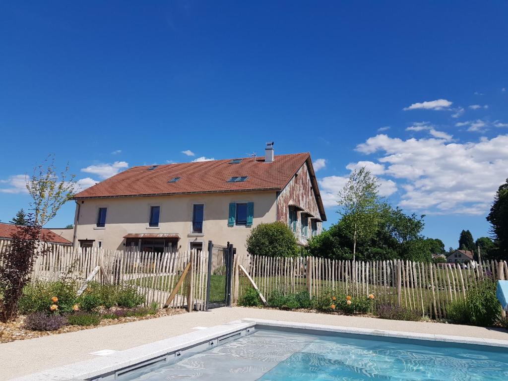 une maison et une piscine en face d'une maison dans l'établissement La Pause Ô Logis, à Saint-Laurent-du-Jura