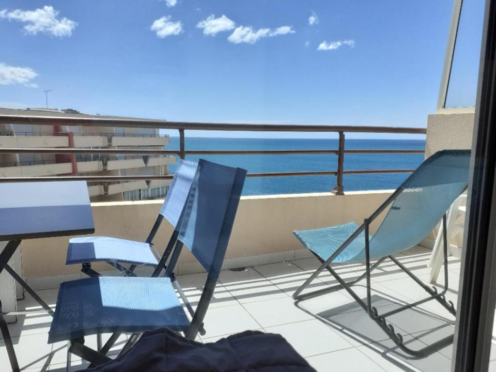 deux chaises et une table sur un balcon avec l'océan dans l'établissement Charmant 2 pièces cabine à Sète, vue mer, parking, terrasse - FR-1-472A-196, à Sète