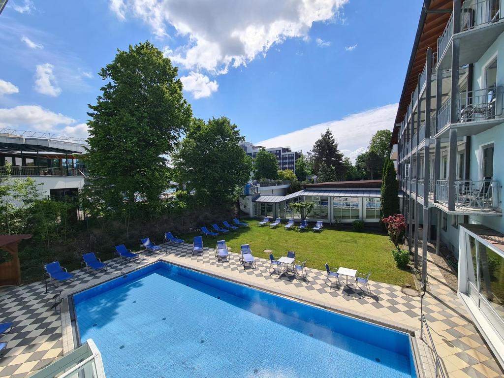 una piscina junto a un edificio con patio en Thermenhotel Tannenhof - Ihr Wohlfühl-Hotel en Bad Füssing