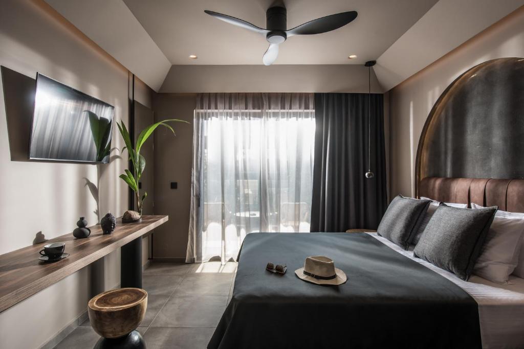 een slaapkamer met een bed met een hoed erop bij Alsus Boutique Hotel - Adults Only in Amoudara Herakliou
