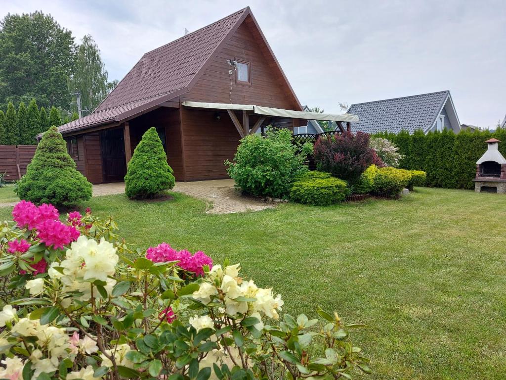 uma casa com um quintal com flores em frente em Rajski ogród Nadole em Nadole