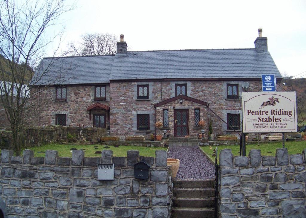a stone house with a sign in front of it at Pentre Riding Stables in Abercraf