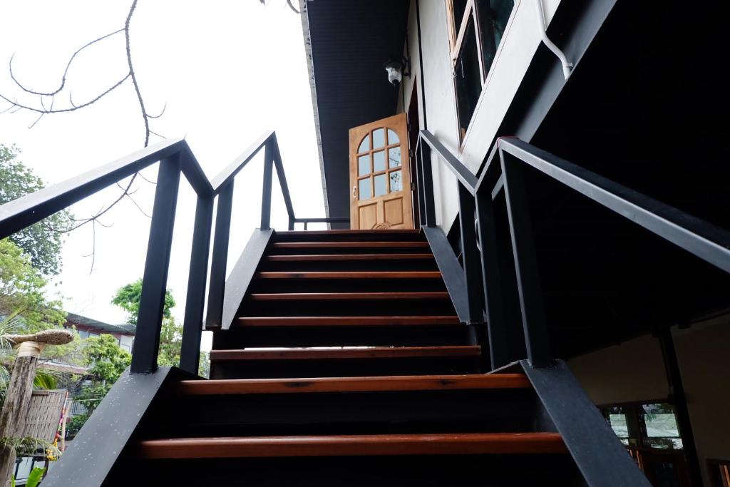 a staircase leading up to a house with a door at Bloom Cafe & Hostel in Ko Lipe