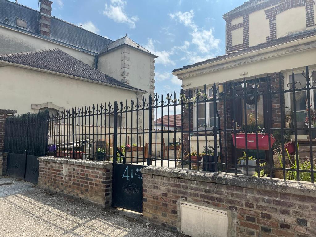 uma cerca preta de ferro forjado em frente a uma casa em Vaudes chambre em Vaudes