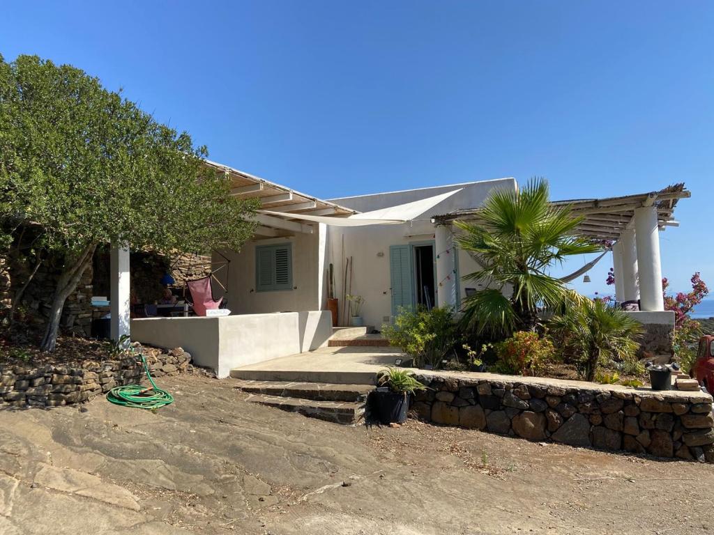 a small white house with a stone wall at Casa Nica in Ustica