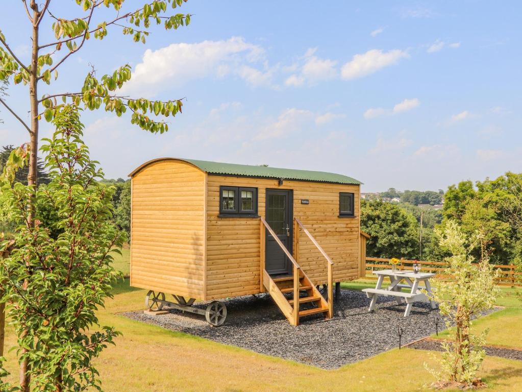 a tiny house with a picnic table in a garden at Sunflower in Redruth