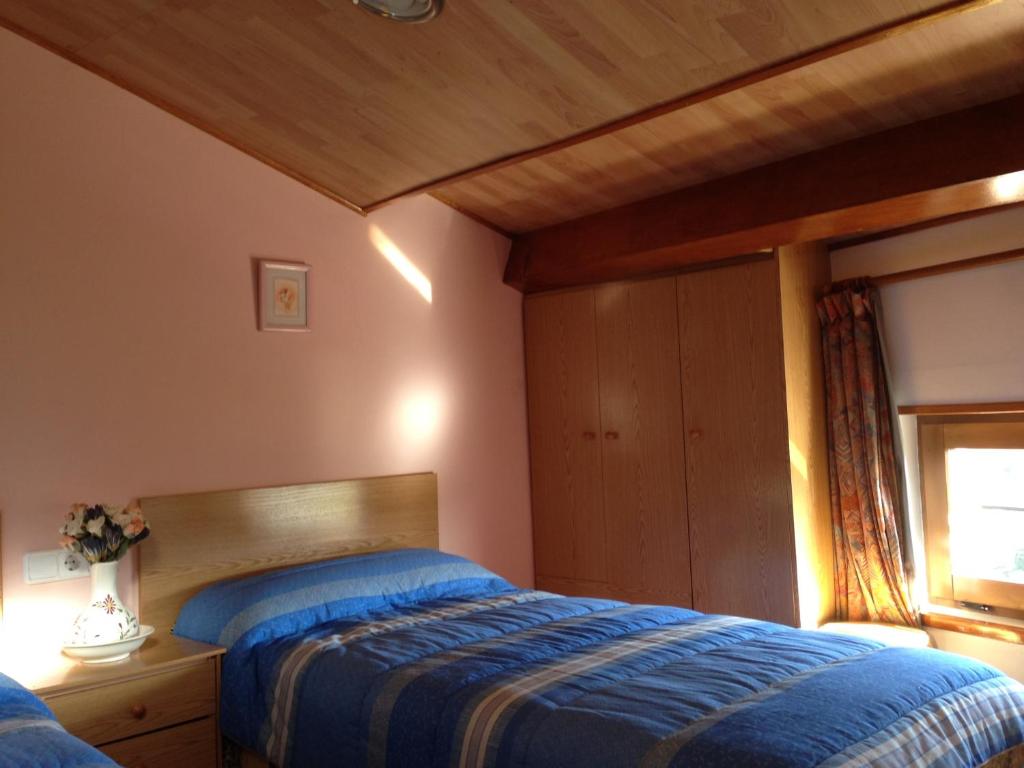 a bedroom with a bed and a window at La Ontina in La Puebla de Valverde