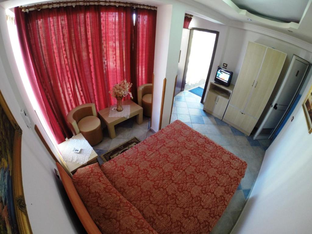 una vista aérea de una sala de estar con cortinas rojas en Hotel Ideal, en Shkodër