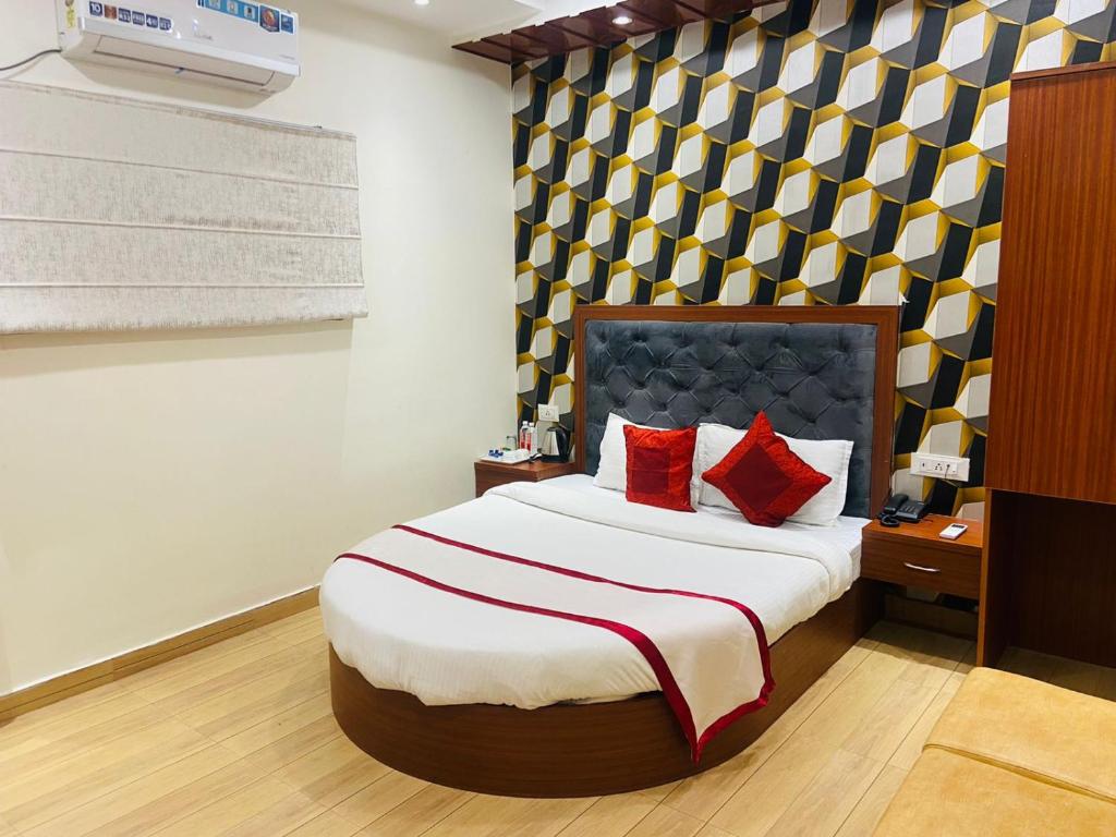 een slaapkamer met een groot bed met rode kussens bij HOTEL S V GRAND in Varanasi