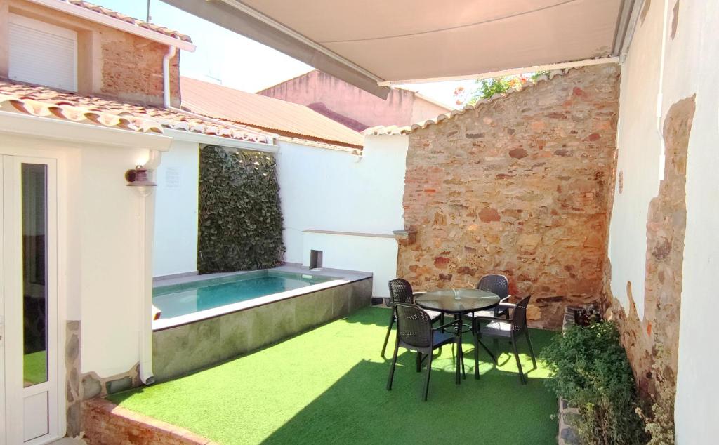 un patio con mesa y sillas y una piscina en Casa Rural La Salamandrija- con piscina- petfriendly, en Cordobilla de Lácara