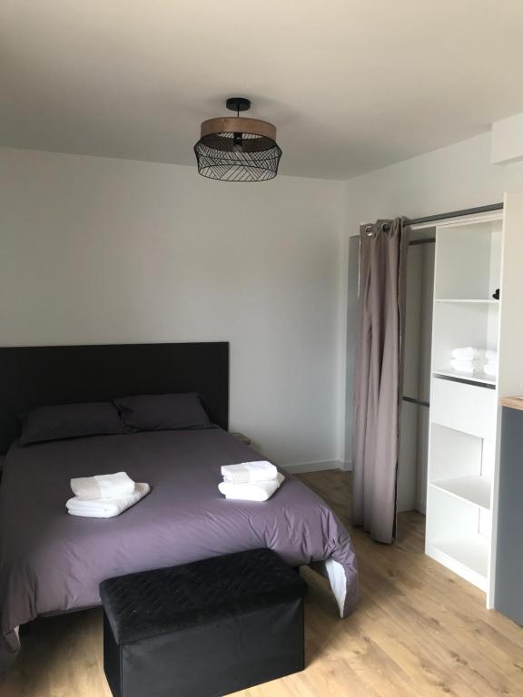 een slaapkamer met een paars bed met een zwart hoofdeinde bij STUDIO A 20 MIN DU PUY DU FOU in Mesnard-la-Barotière