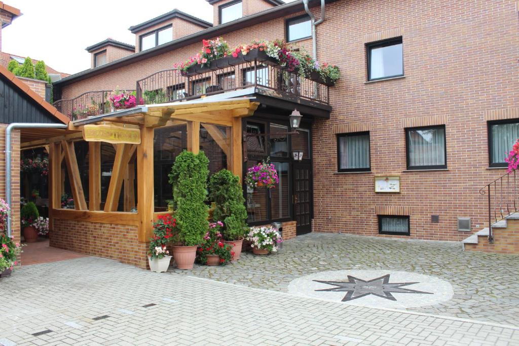 ein Backsteingebäude mit einem Balkon und Blumen darauf in der Unterkunft Hotel und Pension Am Burchardikloster in Halberstadt